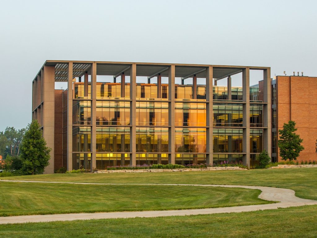 Christopher Center library with the path open in front of it with the rising sun hitting the windows