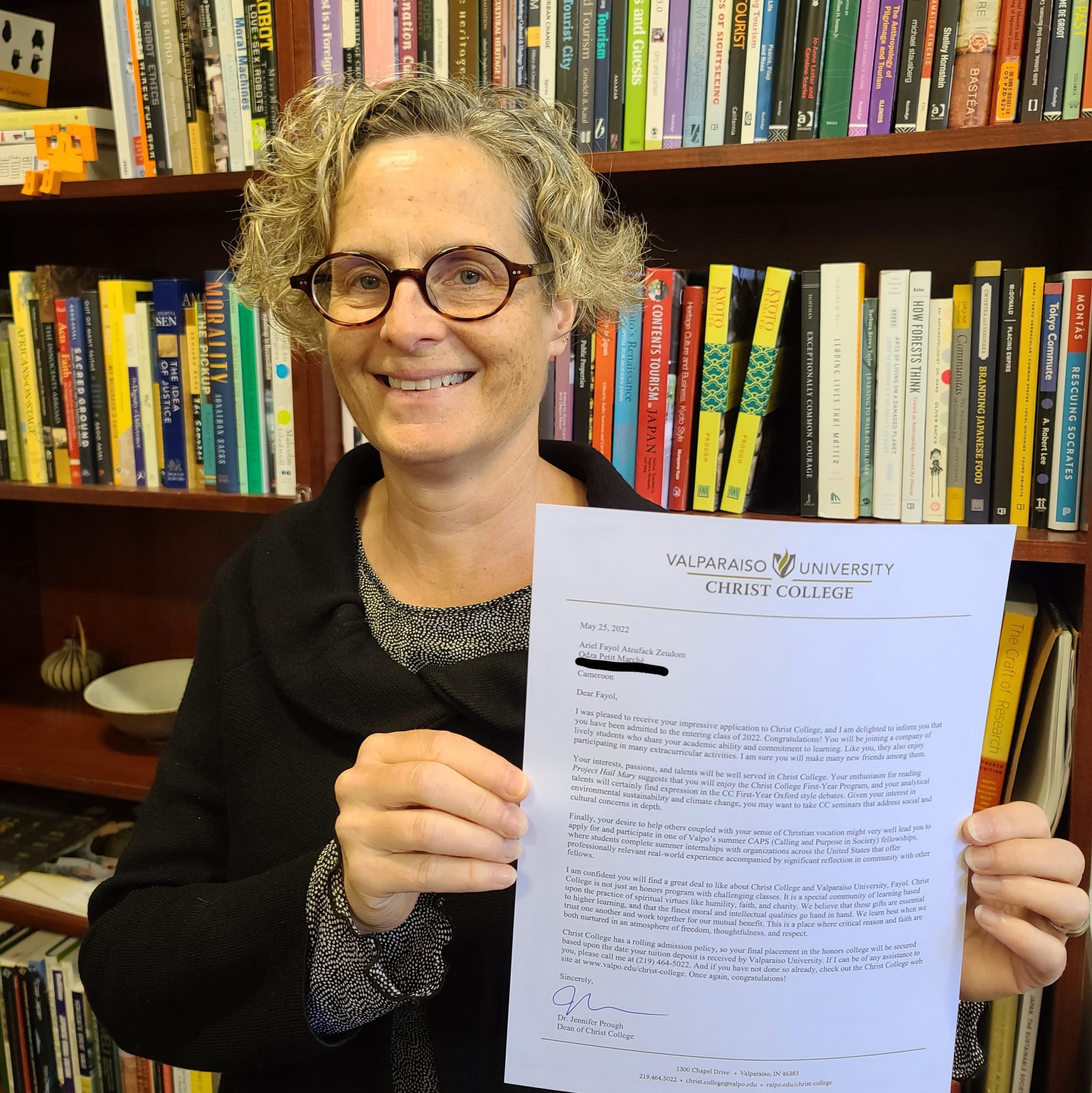 Jennifer Prough ‘91, Ph.D., dean of Christ College — The Honors College and professor of humanities and East Asian studies, smiling and holding up Fayol’s application.