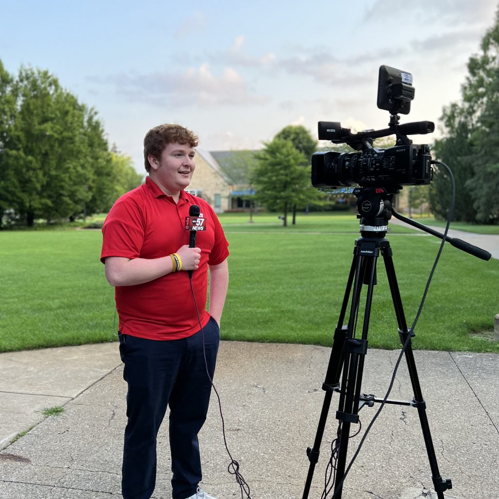 Emmett Twomey '23 delivering a forecast into a professional camera.