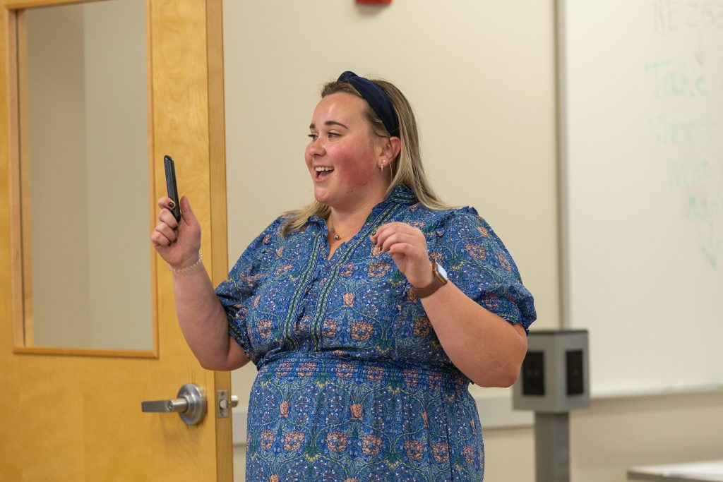 Valparaiso University alumna and Professor Aly Kinzie '19, '20 MHCA, smiling as she teaches a classroom of students.