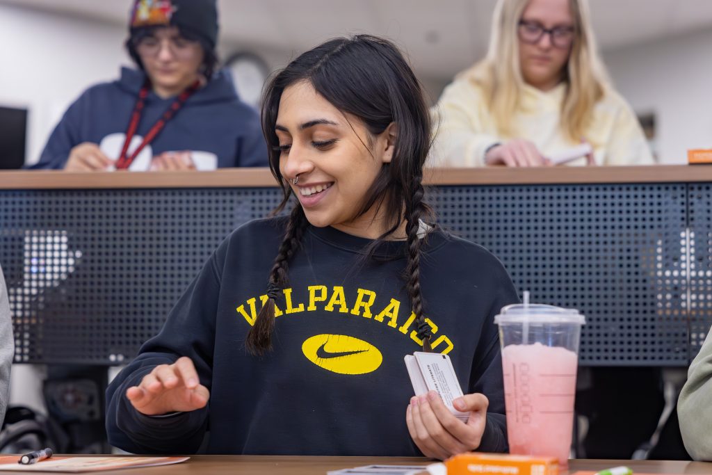 Valpo student smiling while looking down at her desk.