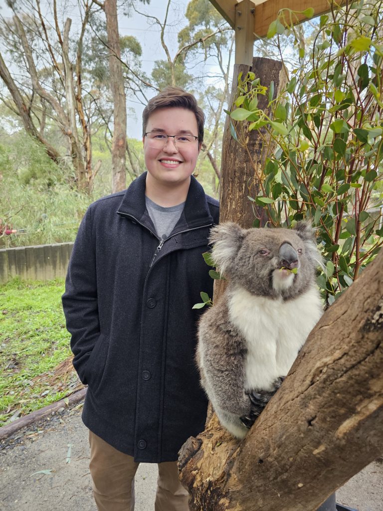 Valparaiso University physics and mathematics student Lane Scheel '25 smiles next to a kiola.