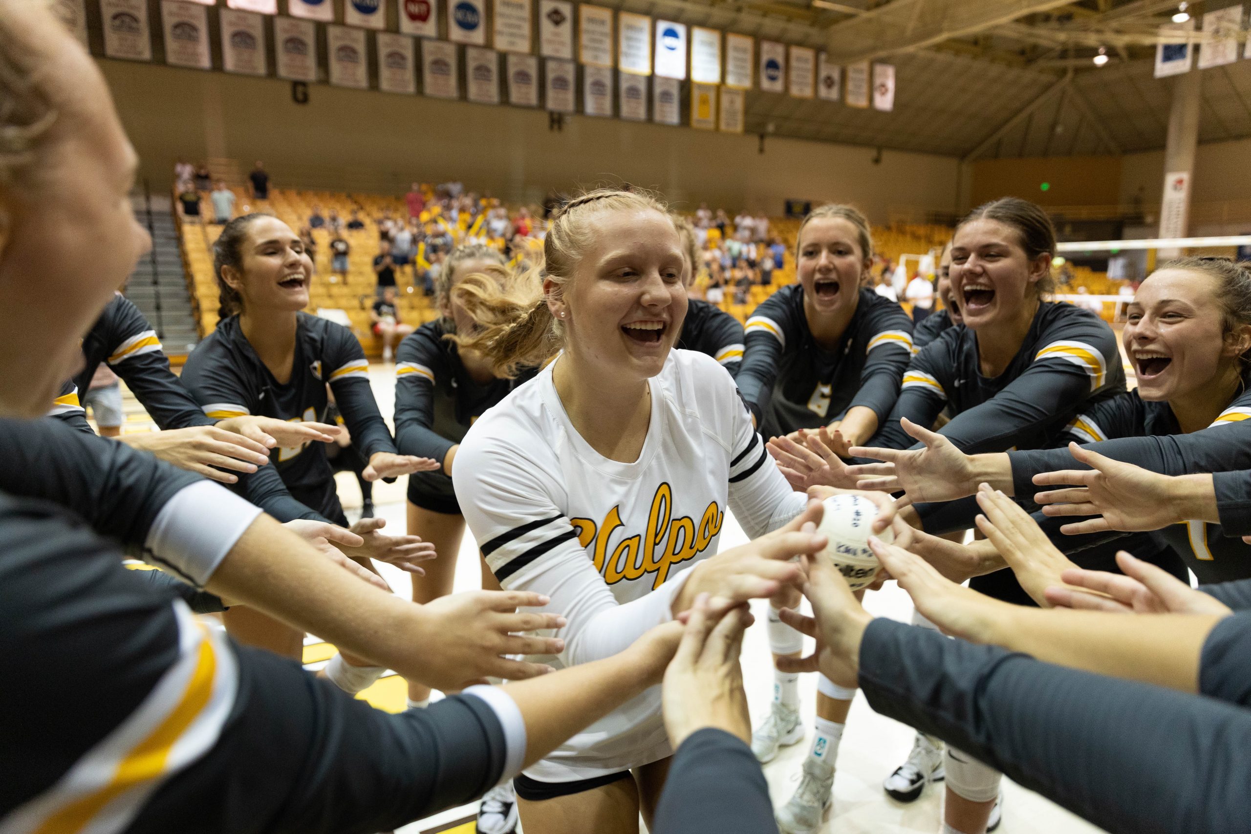 Valparaiso University student-athlete Emma Hickey '26 celebrating with her team after a volleyball match.