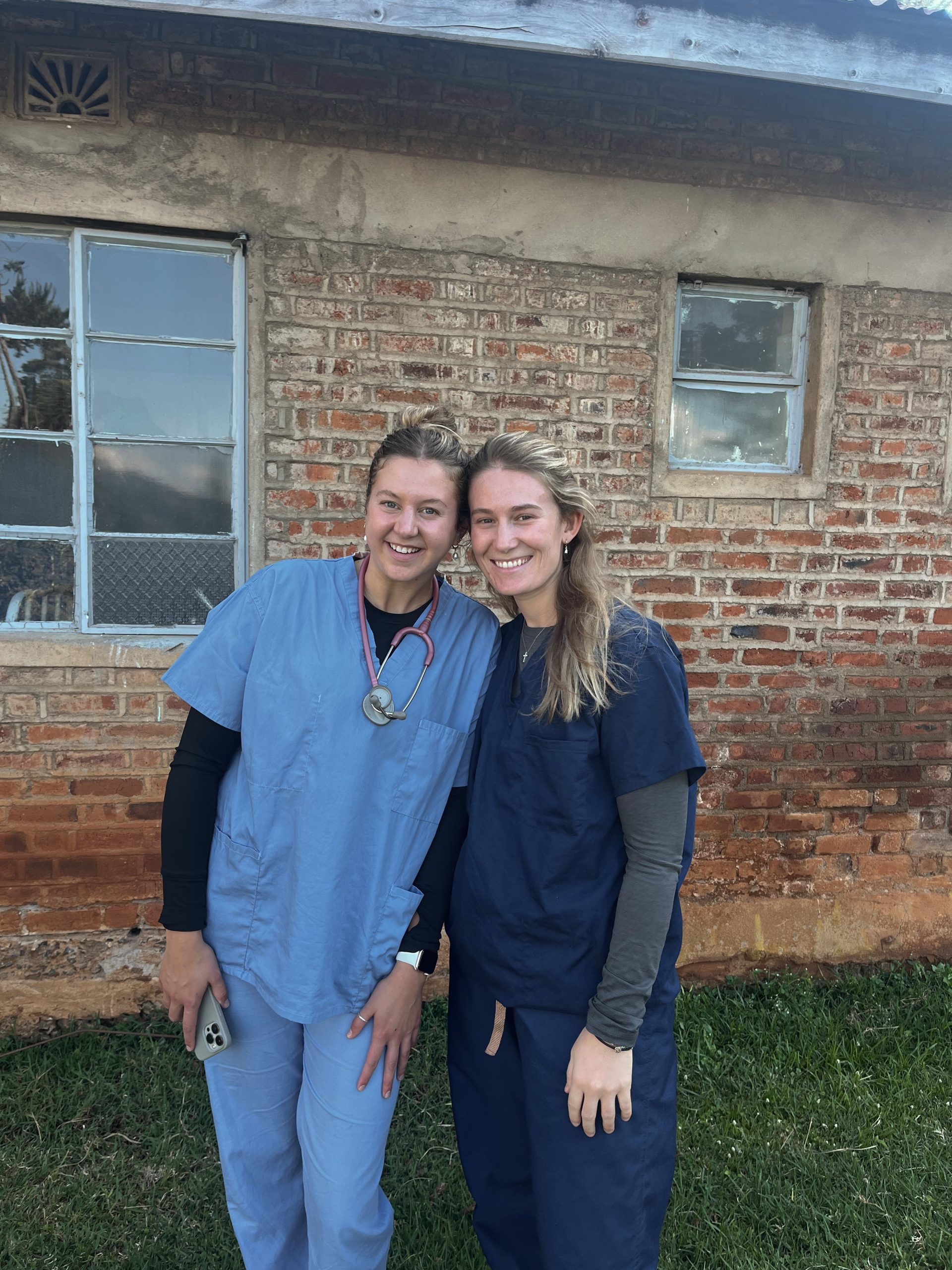 Valparaiso University alumni Cailey Rooker '24 and Rachel Yeager '24 posing for a photo, smiling and wearing medical scrubs.